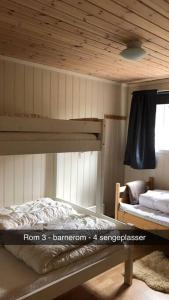 a bedroom with a bunk bed with a wooden ceiling at Koselig familiehytte på vakre Dagali - nær Geilo in Dagali
