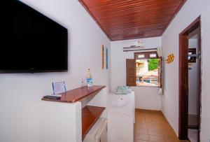 - un salon avec une télévision et un réfrigérateur dans l'établissement Pousada Natal, à Morro de São Paulo