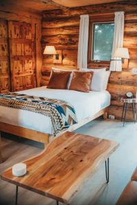 a bedroom with a bed in a log cabin at Wilder and Pine Riverside Cabins in Stevenson