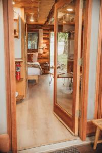 einen Flur mit einem Spiegel und ein Zimmer mit einem Bett in der Unterkunft Wilder and Pine Riverside Cabins in Stevenson