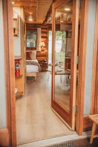 a hallway with a mirror and a room with a bed at Wilder and Pine Riverside Cabins in Stevenson