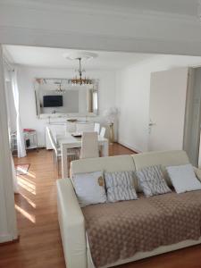 a living room with a couch and a dining room at maison proche du Mont Saint Michel in Pontorson