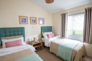 a bedroom with two beds and a window at Bay View Lodge, Brynowen in Borth