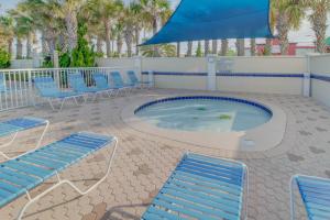 a hot tub with chairs and a blue umbrella at Majestic Beach Resort Tower 2- 1903 in Panama City Beach