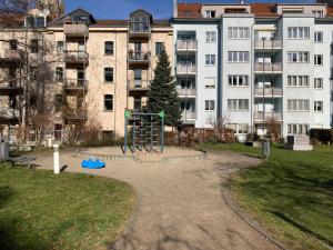 un parque infantil en un parque frente a un edificio en Vicinity KarLi, en Leipzig