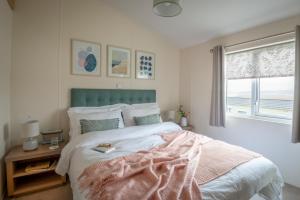 a bedroom with a bed with a view of the ocean at Bay View Lodge, Brynowen in Borth