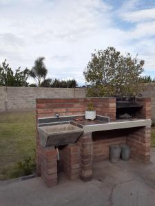 a brick barbecue with a stone sink in a yard at Casa en Los Altos in Chilecito