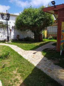 a stone walkway in a yard with a tree at alojamiento Lof tüng in Los Vilos