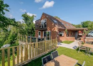 a house with a wooden deck and a patio at Castle Brake Holiday Park in Woodbury