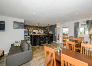 a living room and dining room with a couch and a table at Castle Brake Holiday Park in Woodbury
