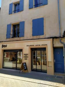 リル・シュル・ラ・ソルギュにあるLa Sorguetteの青い窓と看板が目の前にある建物