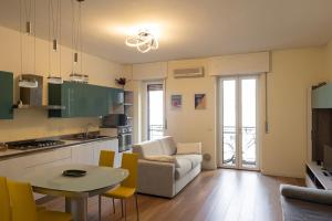 een keuken en een woonkamer met een tafel en stoelen bij Bilocale Moderno ed Esclusivo in Milaan