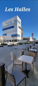 un groupe de tables et de chaises devant un bâtiment dans l'établissement Golden Mont Centre Appartement, à Pau