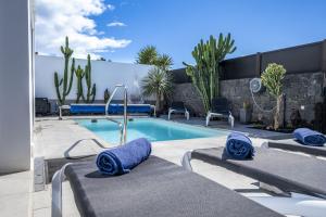 a swimming pool with blue towels in a backyard at Casa Saidera in Playa Blanca
