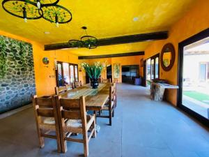 a dining room with a large wooden table and chairs at La Casa del Lago in Malinalco