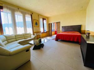 een woonkamer met een bank en een bed bij La Casa del Lago in Malinalco
