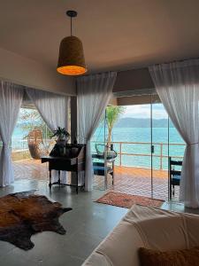 a bedroom with a piano and a view of the ocean at Casa pé na areia para até 14 pessoas em bombinhas in Bombinhas