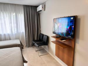 Habitación con TV y silla. en Suite del sol 120 en Pinamar
