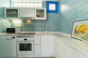 Una cocina blanca con fregadero y microondas. en Trendy Homes Casa Pitera, en Rodalquilar 8 fotos más
