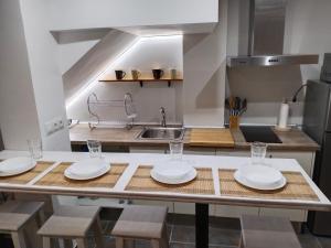 a kitchen with a table with plates and glasses on it at Acogedor apartamento loft in Alhaurín de la Torre