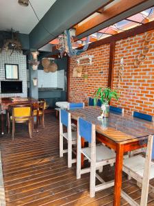 a dining room with a table and chairs and a brick wall at Casa pé na areia para até 14 pessoas em bombinhas in Bombinhas