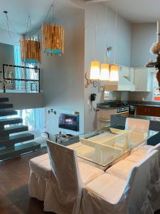 a dining room with a glass table and white chairs at Casa pé na areia para até 14 pessoas em bombinhas in Bombinhas