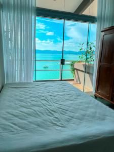 a bedroom with a bed with a view of the ocean at Casa pé na areia para até 14 pessoas em bombinhas in Bombinhas