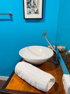 a bathroom with a white bowl sink on a wooden floor at Casa pé na areia para até 14 pessoas em bombinhas in Bombinhas