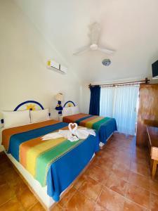 a bedroom with two beds with colorful sheets at Hotel Boutique Eden Costa in Santa Cruz Huatulco