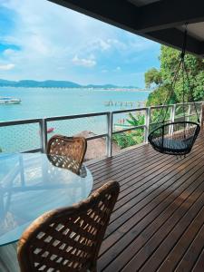 a porch with a swing and a table and chairs at Casa pé na areia para até 14 pessoas em bombinhas in Bombinhas