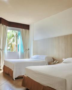 pokój hotelowy z 2 łóżkami i oknem w obiekcie Palmar Del Sol Hotel w mieście Quevedo