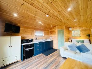 a living room with a white couch and a kitchen at Hwyl in Abbey-Cwmhir