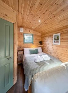 a bedroom with a bed in a wooden cabin at Hwyl in Abbey-Cwmhir