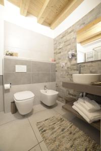 uma casa de banho com um WC branco e um lavatório. em b&b Due Perle em Chioggia