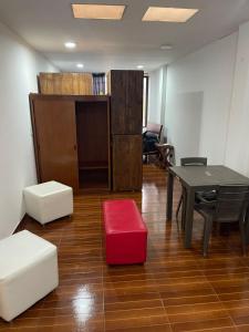 sala de estar con mesa y taburete rojo en Apt estudio calle97301, en Bogotá