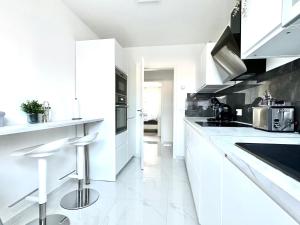 una cocina blanca con electrodomésticos blancos y encimeras blancas en Stilvolles Apartment in Bonn en Bonn