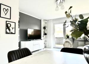 a living room with a television and a table at Stilvolles Apartment in Bonn in Bonn