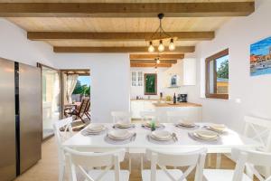 Il comprend une cuisine et une salle à manger avec une table et des chaises blanches. dans l'établissement Villa David - luxurious secluded villa with a heated pool, à Butkovići