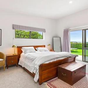 Un dormitorio con una cama grande y una ventana en Coastal Paradise, en Raglan