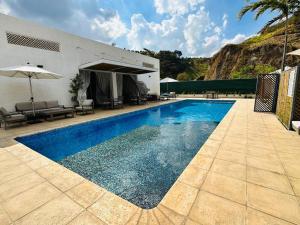 a swimming pool in front of a building with an umbrella at Habitación privada in Guatemala