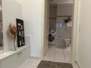 a bathroom with a washing machine and a toilet at MORINA Residences in Mainz