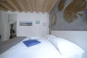 a bedroom with a white bed with two pillows at b&b Due Perle in Chioggia