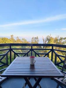 uma chávena de café sentada numa mesa de madeira na varanda em Fraser Hill Silverpart Resort A3-1-1 Forest View With Lift em Bukit Fraser