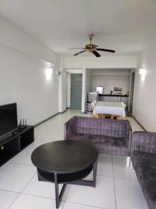 uma sala de estar com um sofá e uma mesa em Fraser Hill Silverpart Resort A3-1-1 Forest View With Lift em Bukit Fraser