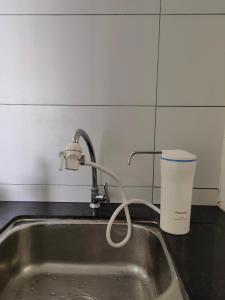 um lavatório de cozinha com uma torneira e uma chávena em Fraser Hill Silverpart Resort A3-1-1 Forest View With Lift em Bukit Fraser