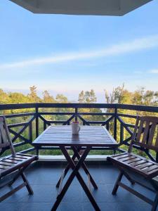 uma mesa e duas cadeiras numa varanda em Fraser Hill Silverpart Resort A3-1-1 Forest View With Lift em Bukit Fraser
