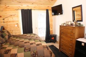 1 dormitorio con 1 cama, vestidor y TV en The Old Tioga Inn Bed and Breakfast, en Fairmount Springs