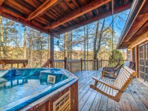a hot tub on a wooden deck with a bench at Bear Cave Haus, 2 Bedrooms, Fireplace, Hot Tub, Pool Table, WiFi, Sleeps 8 in Gatlinburg