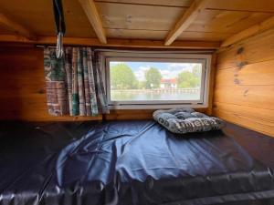 a small room with a window and a bed at Hausfloßvermietung auf der Peene am Kummerower See in Mecklenburg Vorpommern in Dargun