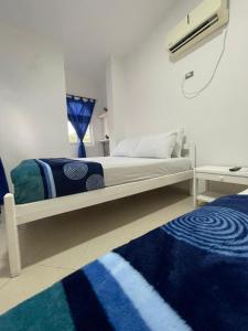 Schlafzimmer mit einem Bett in Blau und Weiß in der Unterkunft Hotel Palma Azul Beach in Coveñas